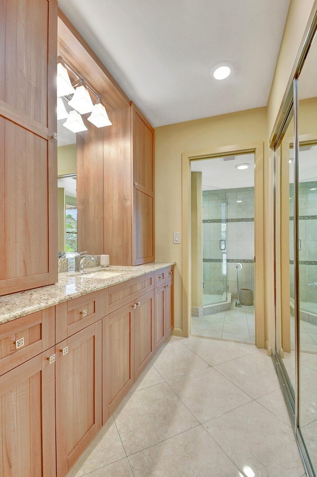 bathroom featuring an enclosed shower, vanity, and tile patterned floors