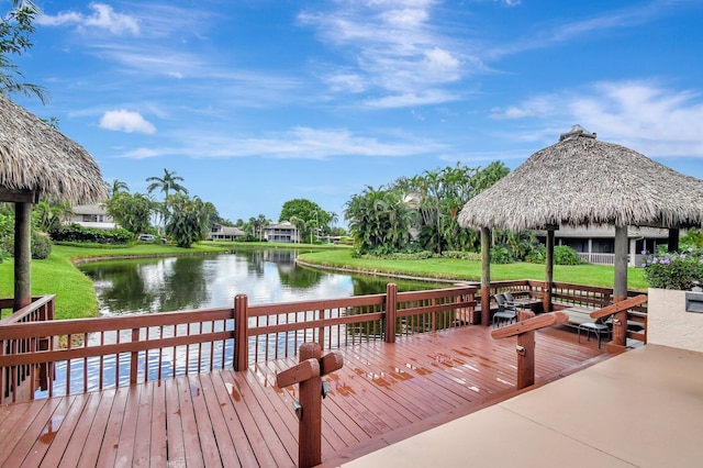 view of dock with a deck with water view, a lawn, and a gazebo