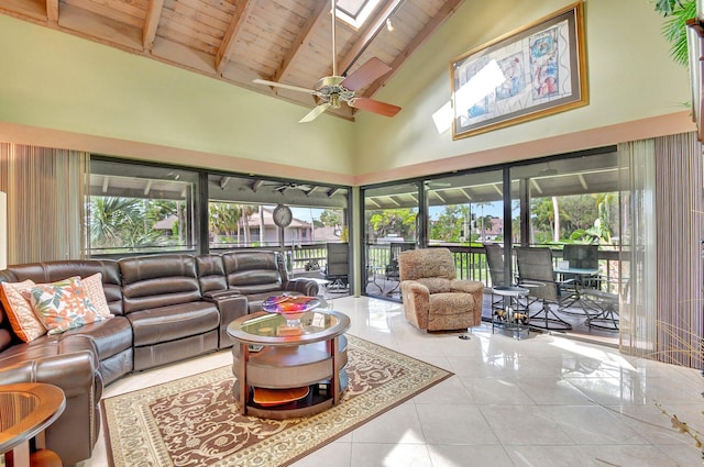 living room featuring ceiling fan, light tile patterned floors, high vaulted ceiling, a skylight, and wood ceiling