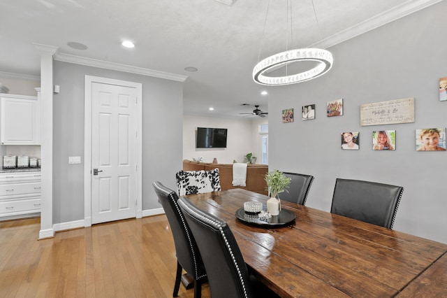 dining area featuring ceiling fan with notable chandelier, light wood-type flooring, and crown molding