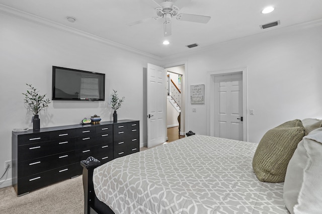 carpeted bedroom with ornamental molding and ceiling fan