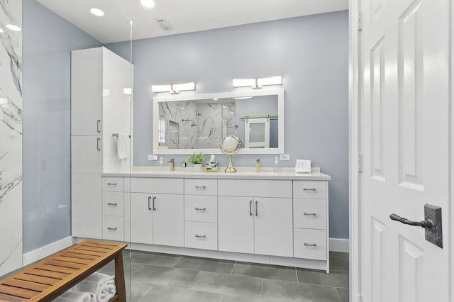 bathroom with walk in shower, vanity, and tile patterned flooring