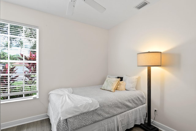 bedroom featuring ceiling fan, multiple windows, and wood-type flooring