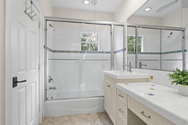 bathroom featuring shower / bath combination with glass door, a healthy amount of sunlight, tile patterned floors, and vanity