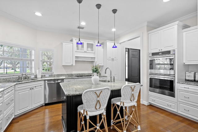 kitchen with white cabinetry, appliances with stainless steel finishes, dark hardwood / wood-style flooring, sink, and an island with sink