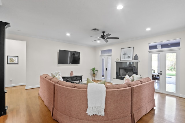 living room featuring french doors, crown molding, ceiling fan, and light hardwood / wood-style flooring