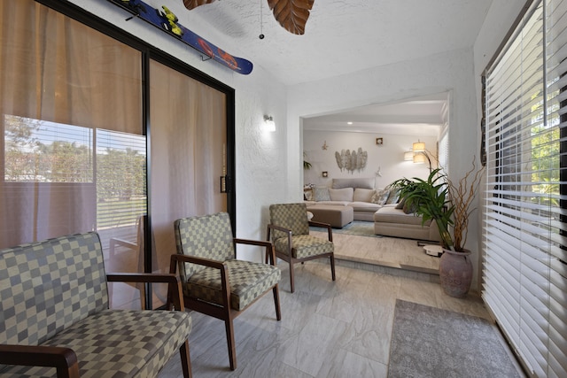 sitting room featuring plenty of natural light and ceiling fan