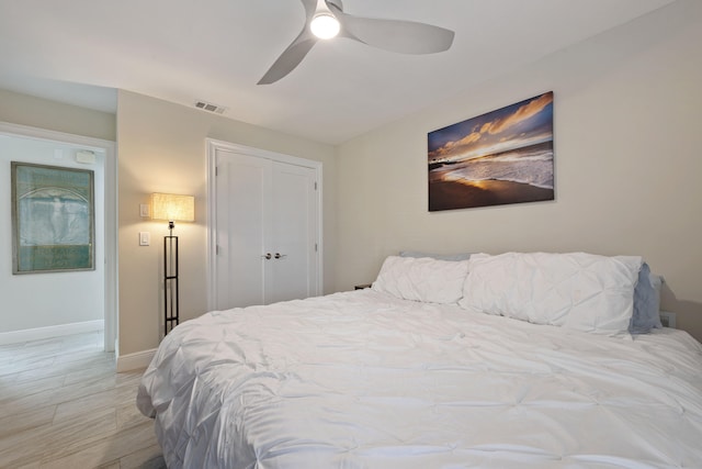 bedroom featuring ceiling fan, light hardwood / wood-style floors, and a closet