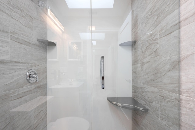 bathroom featuring a tile shower and toilet