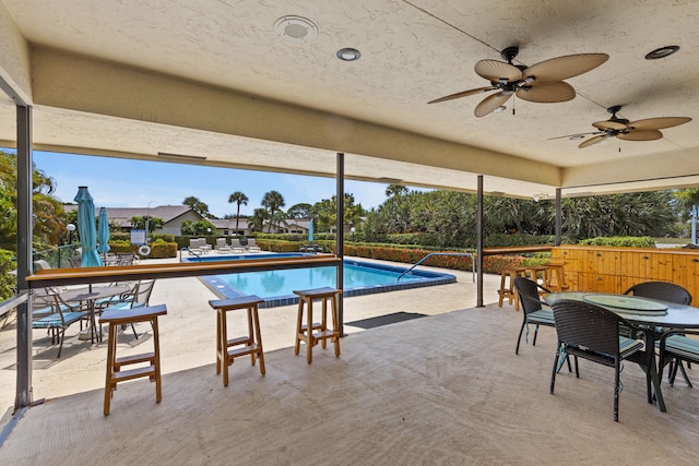 view of swimming pool with ceiling fan and a patio area