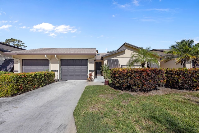 single story home with a garage and a front lawn