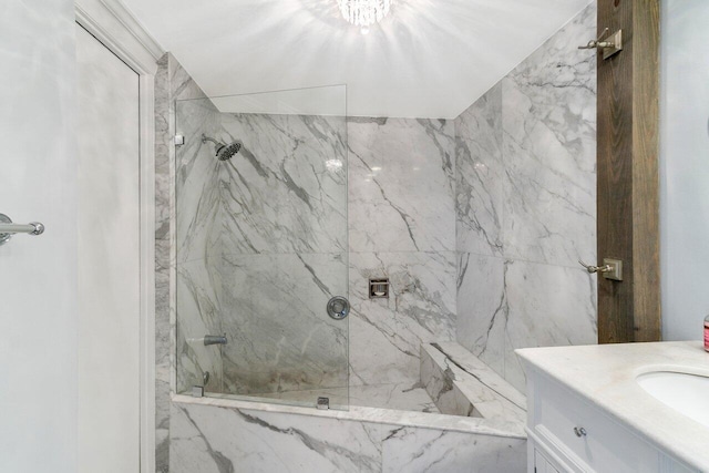 bathroom with tiled shower and vanity