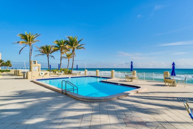 view of pool with a patio and a water view