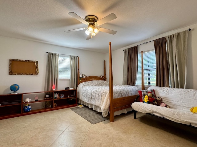 tiled bedroom featuring ceiling fan and a textured ceiling