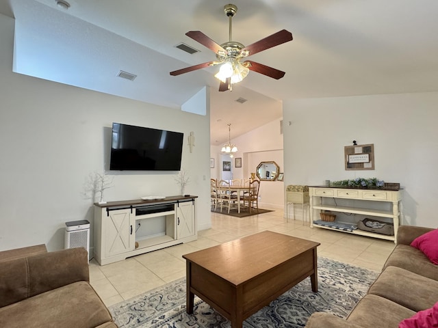 living room with ceiling fan with notable chandelier, vaulted ceiling, and light tile patterned flooring