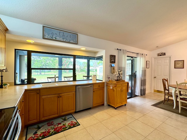 kitchen with a textured ceiling, stainless steel appliances, vaulted ceiling, sink, and light tile patterned floors