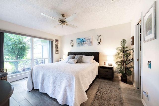 bedroom with wood-type flooring, ceiling fan, and a textured ceiling