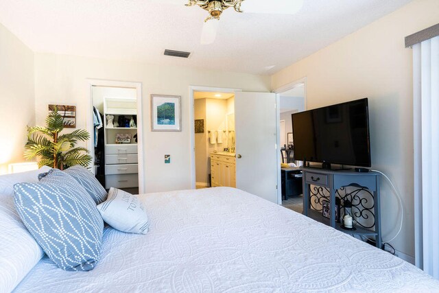 bedroom with ensuite bath, ceiling fan, and a closet