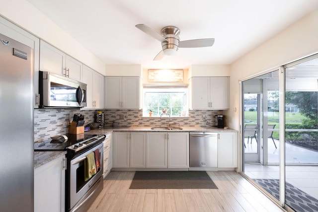 kitchen featuring stainless steel appliances, sink, tasteful backsplash, and light hardwood / wood-style flooring