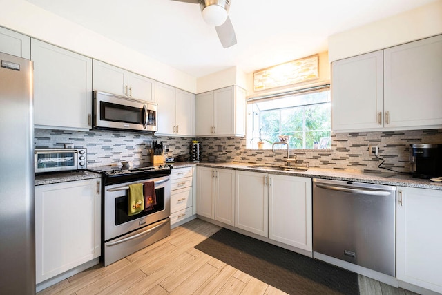 kitchen featuring appliances with stainless steel finishes, decorative backsplash, and white cabinets