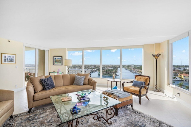 living room with expansive windows, plenty of natural light, and a water view