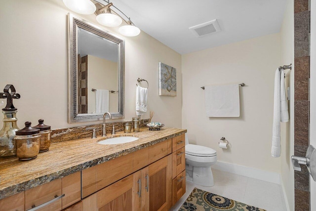 bathroom featuring tile patterned flooring, vanity, and toilet