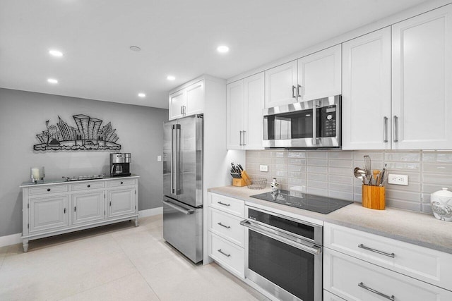 kitchen with stainless steel appliances, white cabinets, and tasteful backsplash