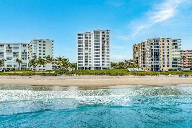 view of swimming pool featuring a view of the beach and a water view