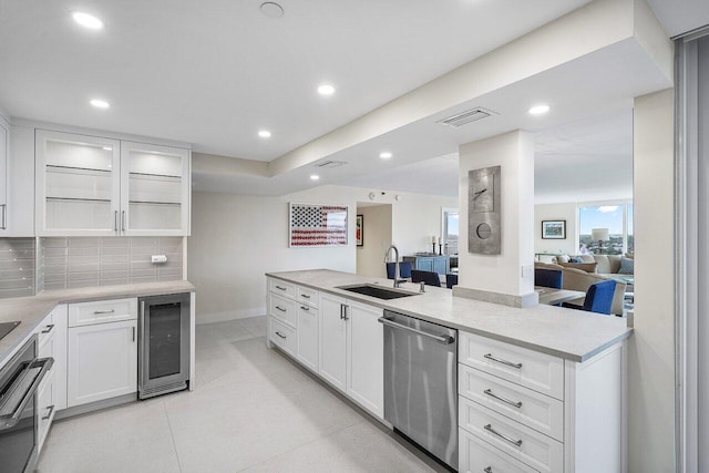 kitchen featuring dishwasher, decorative backsplash, sink, white cabinetry, and wine cooler