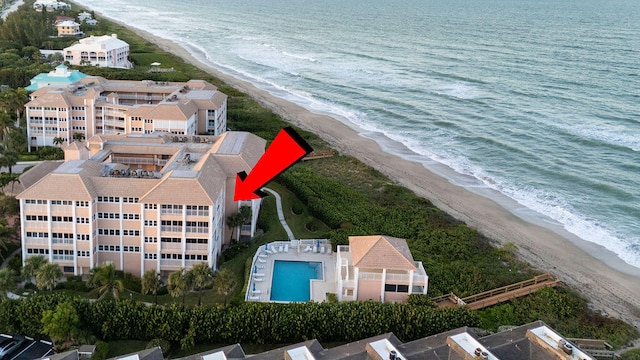 drone / aerial view featuring a water view and a view of the beach