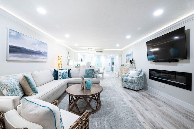 living room with light hardwood / wood-style flooring and crown molding