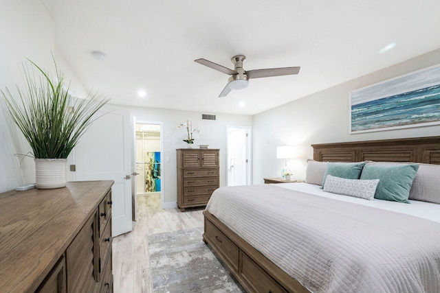 bedroom with ceiling fan, ensuite bath, and light hardwood / wood-style flooring