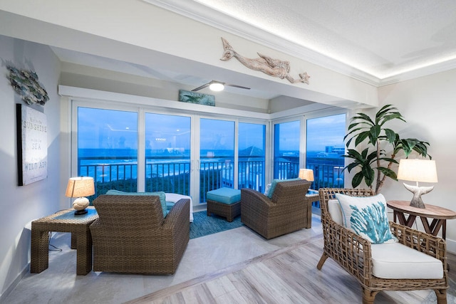 living room with wood-type flooring, a water view, and crown molding