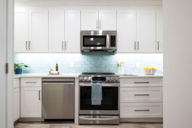 kitchen featuring light hardwood / wood-style floors, white cabinetry, decorative backsplash, and appliances with stainless steel finishes