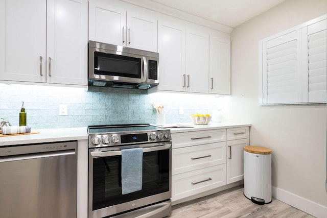 kitchen featuring white cabinets, appliances with stainless steel finishes, light hardwood / wood-style floors, and tasteful backsplash