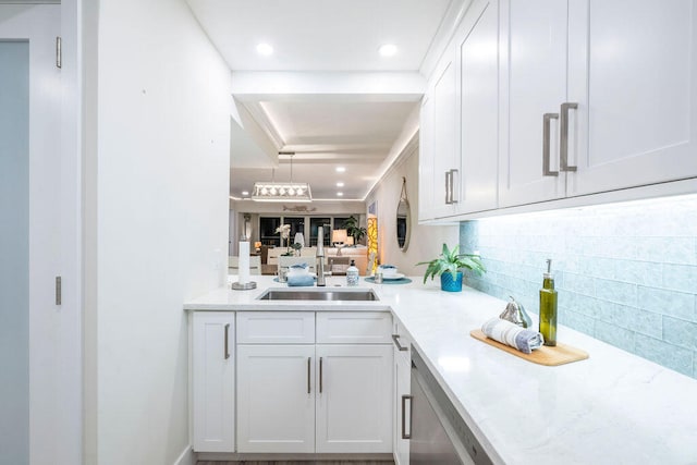 bar with sink, decorative backsplash, and white cabinets