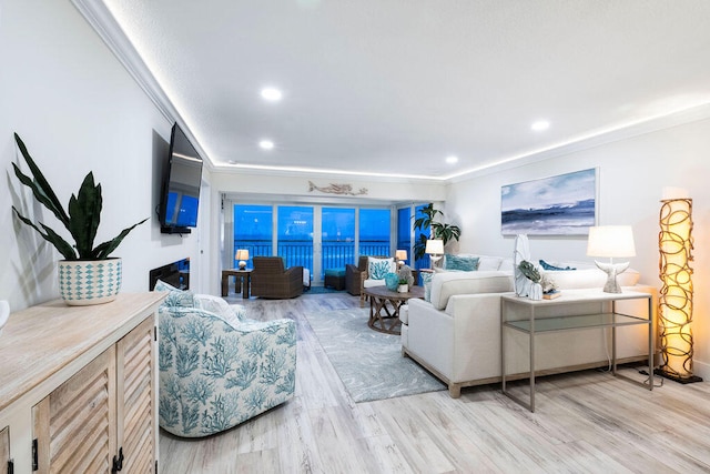 living room featuring light wood-type flooring and crown molding