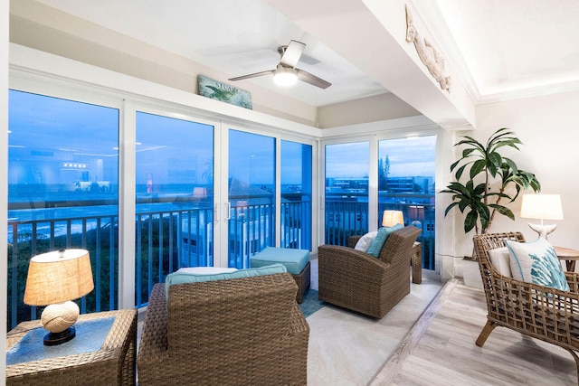 sunroom with a water view and ceiling fan