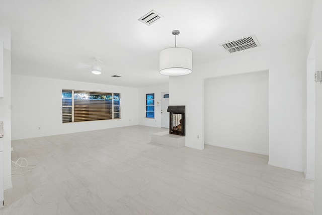 unfurnished living room with a multi sided fireplace