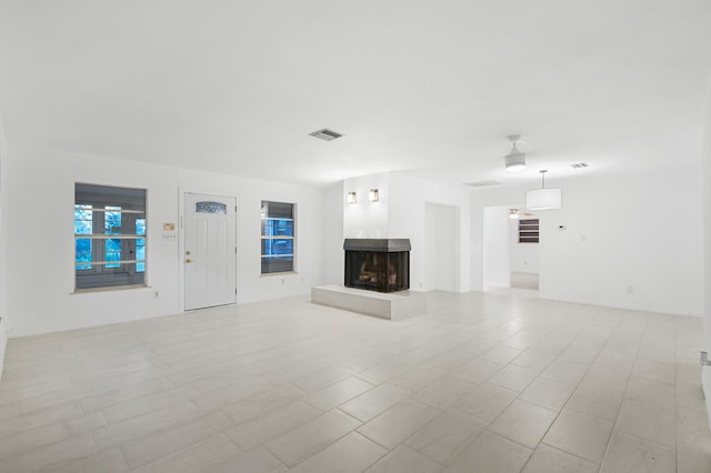 unfurnished living room featuring a multi sided fireplace