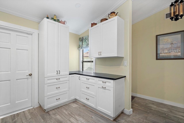 kitchen with white cabinetry, crown molding, and light wood-type flooring