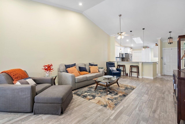 living room with crown molding, ceiling fan, lofted ceiling, and light wood-type flooring