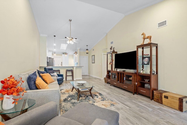 living room with ceiling fan, light hardwood / wood-style flooring, high vaulted ceiling, and ornamental molding