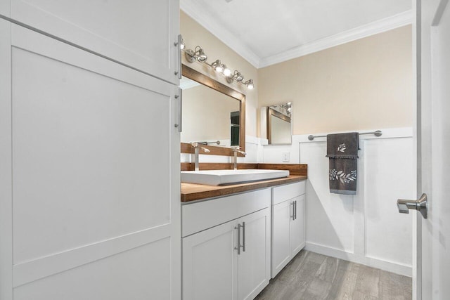 bathroom featuring hardwood / wood-style floors, vanity, and crown molding