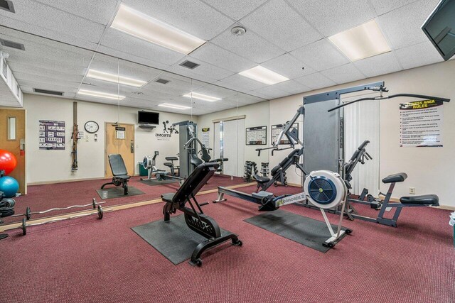 workout area featuring a paneled ceiling and carpet