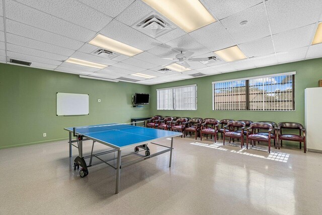 recreation room with a drop ceiling and ceiling fan