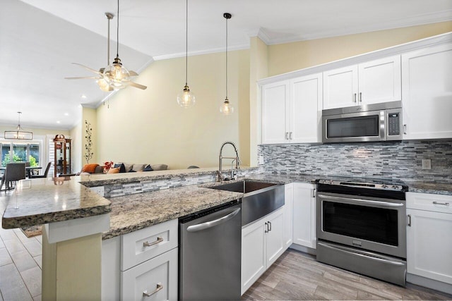 kitchen with white cabinetry, kitchen peninsula, appliances with stainless steel finishes, and vaulted ceiling