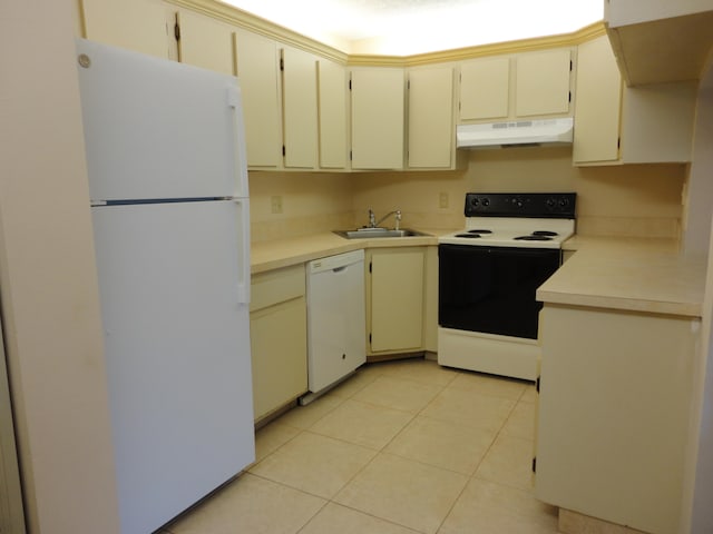 kitchen with cream cabinetry, sink, white appliances, and light tile patterned floors