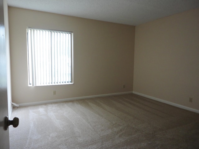 carpeted spare room with a textured ceiling