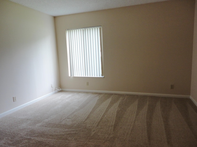 carpeted empty room with a textured ceiling